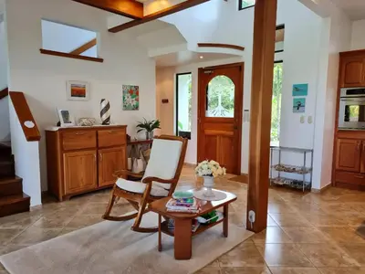 a living room with a table and a chair at Villa Corazón - private beach at Lake Arenal in Nuevo Arenal