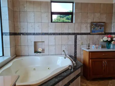 a large bathroom with a tub and a sink at Villa Corazón - private beach at Lake Arenal in Nuevo Arenal