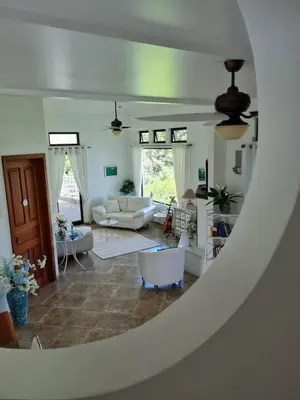 a living room with a couch and a table at Villa Corazón - private beach at Lake Arenal in Nuevo Arenal