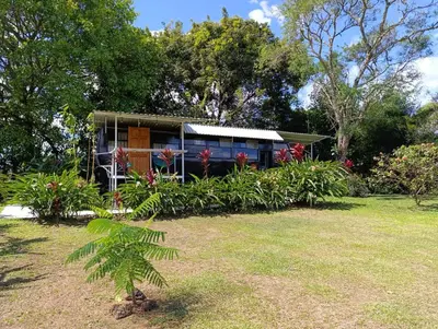 a small house in a garden with a yard at The Dreamcatcher Bus in Sarchí
