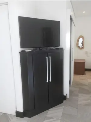a flat screen tv on top of a black entertainment center at Pura vida apartments in Quepos