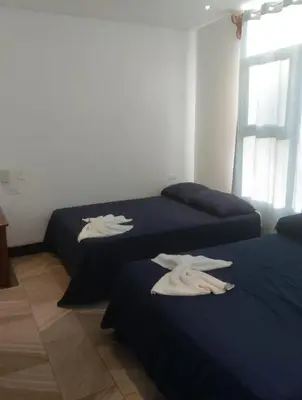 two beds in a room with white towels on them at Pura vida apartments in Quepos