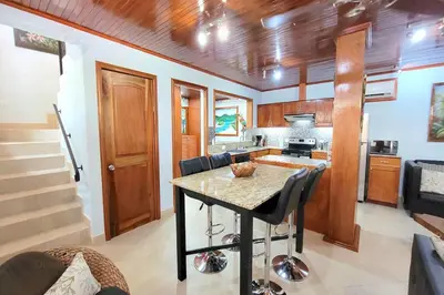 a kitchen with a table and some chairs in a room at LA BUENA VIDA CONDO in Tamarindo