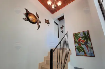 a hallway with a staircase with a turtle on the wall at LA BUENA VIDA CONDO in Tamarindo