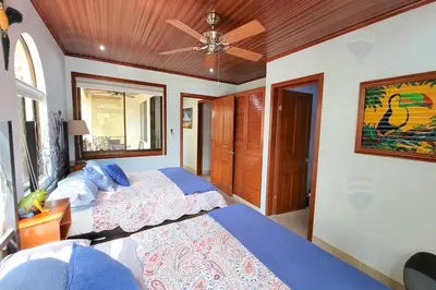 a bedroom with two beds and a ceiling fan at LA BUENA VIDA CONDO in Tamarindo