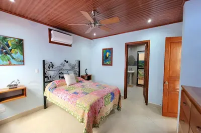 a bedroom with a bed and a ceiling fan at LA BUENA VIDA CONDO in Tamarindo