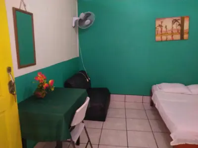 a room with a table and a bed and a green wall at Hotel Marruecos C.R. in San José