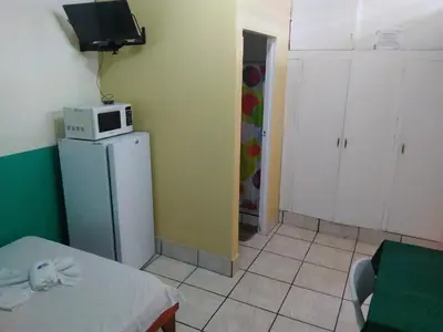 a small room with a microwave on top of a refrigerator at Hotel Marruecos C.R. in San José