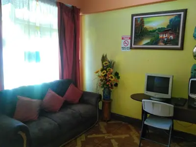 a living room with a couch and a television at Hotel Marruecos C.R. in San José