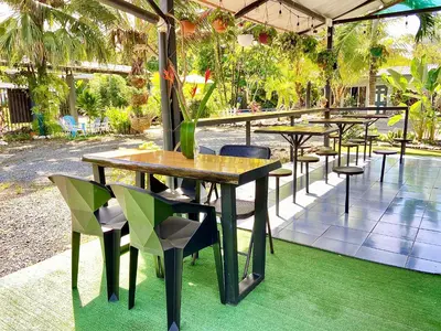 a group of tables and chairs on a patio at Rooms & Pool Macaws in Uvita