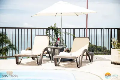 two chairs and a table with an umbrella on a patio at Palo Rosa in Quepos