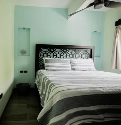a bedroom with a large bed with white sheets at Palo Rosa in Quepos