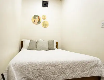 a bedroom with a bed with white sheets and pillows at Palo Rosa in Quepos