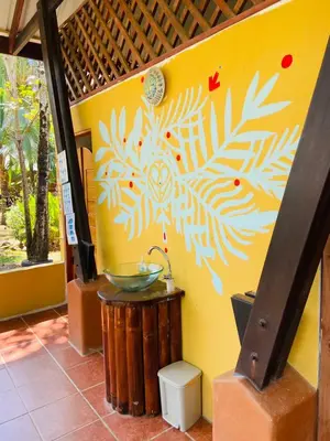 a bathroom with a sink on a yellow wall at Luminosa Uvita Hostel in Uvita
