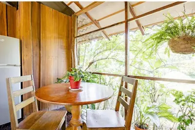 a small table and chairs in a room with a window at Luminosa Uvita Hostel in Uvita