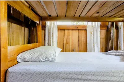 a bed in a room with a wooden ceiling at Luminosa Uvita Hostel in Uvita