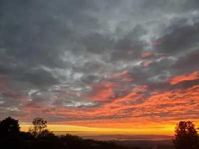 a cloudy sky at sunset with trees in the foreground at Ocean view in Monteverde Costa Rica