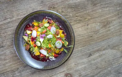 a salad in a bowl on a wooden table at Alta Las Palomas Hotel in San José