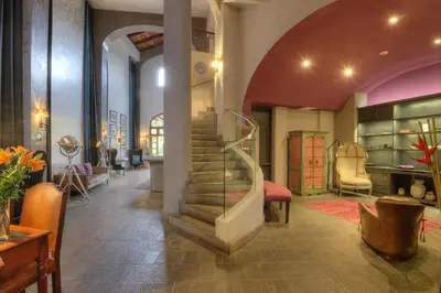 a lobby with a spiral staircase in a building at Alta Las Palomas Hotel in San José