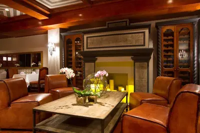 a dining room with a table and chairs and a fireplace at Alta Las Palomas Hotel in San José