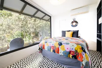 a bedroom with a bed and a large window at Dantica Cloud Forest Lodge in San Gerardo de Dota