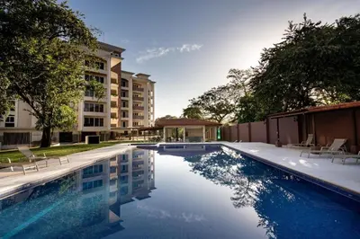 a swimming pool with chairs next to a building at Brandnew Luxury 2Bdr condo✰Stunning view✰Fast wifi in Tamarindo