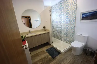 a bathroom with a shower and a toilet and a mirror at Brandnew Luxury 2Bdr condo✰Stunning view✰Fast wifi in Tamarindo