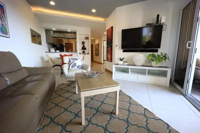 a living room with a couch and a flat screen tv at Brandnew Luxury 2Bdr condo✰Stunning view✰Fast wifi in Tamarindo