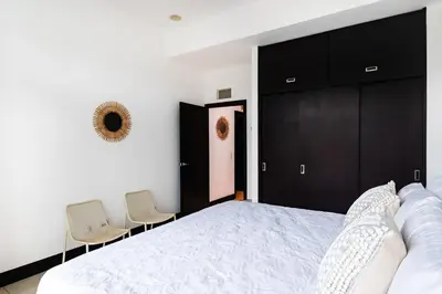 a bedroom with a large bed and two chairs at Sea La Vie Suites - By The Beach in Tamarindo