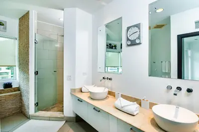 a bathroom with two sinks and a shower at Sea La Vie Suites - By The Beach in Tamarindo