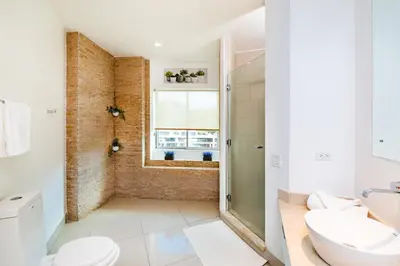 a bathroom with a shower and a toilet and a sink at Sea La Vie Suites - By The Beach in Tamarindo