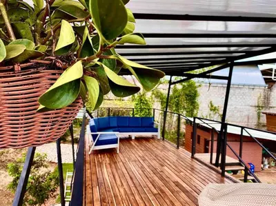 a wooden deck with a blue couch and a plant at Hoja Azul Loft Guanacaste in Hojancha