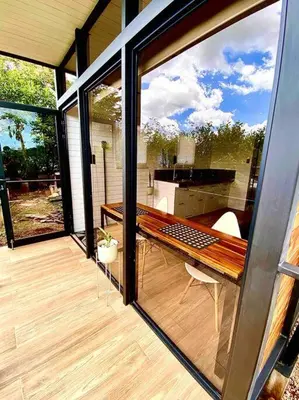 a screened in porch with a view of a kitchen at Hoja Azul Loft Guanacaste in Hojancha