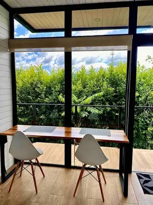 a table and two chairs in front of a large window at Hoja Azul Loft Guanacaste in Hojancha