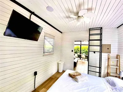 a bedroom with a wall with a flat screen tv at Hoja Azul Loft Guanacaste in Hojancha