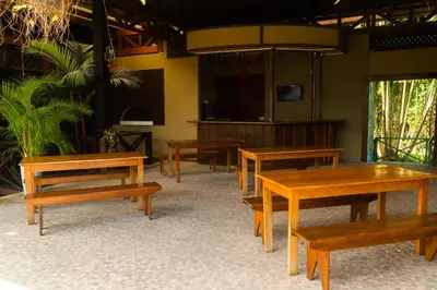 a group of wooden tables and benches in a room at La Fortuna Natural Green in Fortuna