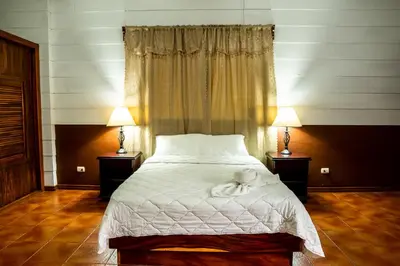 a bedroom with a large bed with two lamps at La Fortuna Natural Green in Fortuna