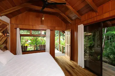 a bedroom with a bed and a large window at La Fortuna Natural Green in Fortuna