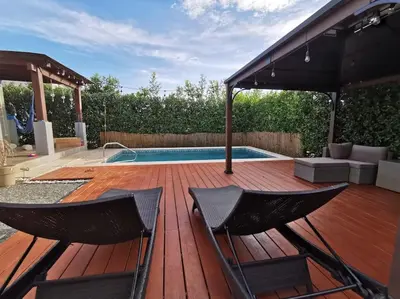 a deck with two chairs and a swimming pool at Playa Tamarindo, CasaMar de Tamarindo in Tamarindo