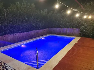 a swimming pool in a backyard at night with lights at Playa Tamarindo, CasaMar de Tamarindo in Tamarindo