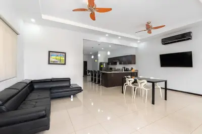 a living room with a black couch and a table at Playa Tamarindo, CasaMar de Tamarindo in Tamarindo