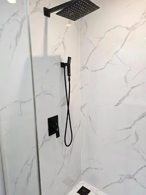 a shower in a white bathroom with marble walls at Stunning 9th Flr Pacific Ocean and Mtn View in Jacó