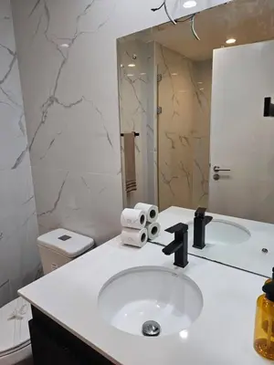a bathroom with a sink and a toilet and a mirror at Stunning 9th Flr Pacific Ocean and Mtn View in Jacó