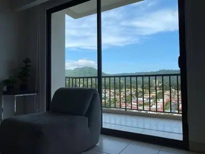 a chair sitting in front of a large window at Stunning 9th Flr Pacific Ocean and Mtn View in Jacó