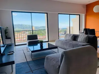 a living room with a couch and a table at Stunning 9th Flr Pacific Ocean and Mtn View in Jacó