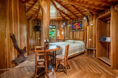 a bedroom with a bed and a table and chairs at Casitas del Bosque Monteverde. in Monteverde Costa Rica