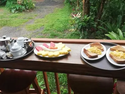 a table with two plates of food on it at Casitas del Bosque Monteverde. in Monteverde Costa Rica