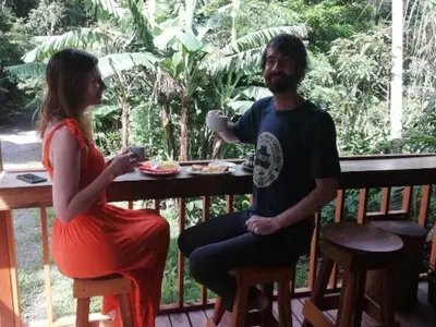 a man and a woman sitting at a table eating food at Casitas del Bosque Monteverde. in Monteverde Costa Rica