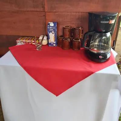 a table with a coffee maker on a red napkin at Cabañas Daneysha in Tortuguero