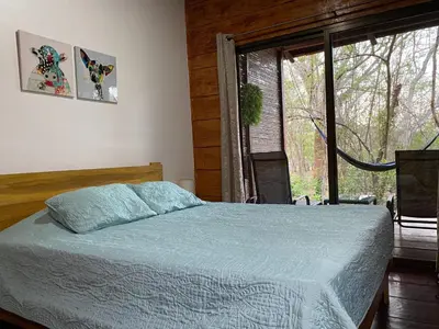 a bedroom with a bed and a large window at Casa Natural Madera in Brasilito